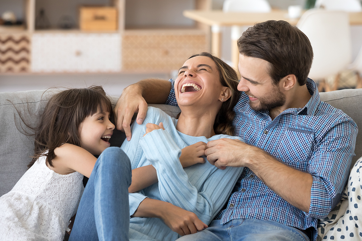 family laughing on the couch image